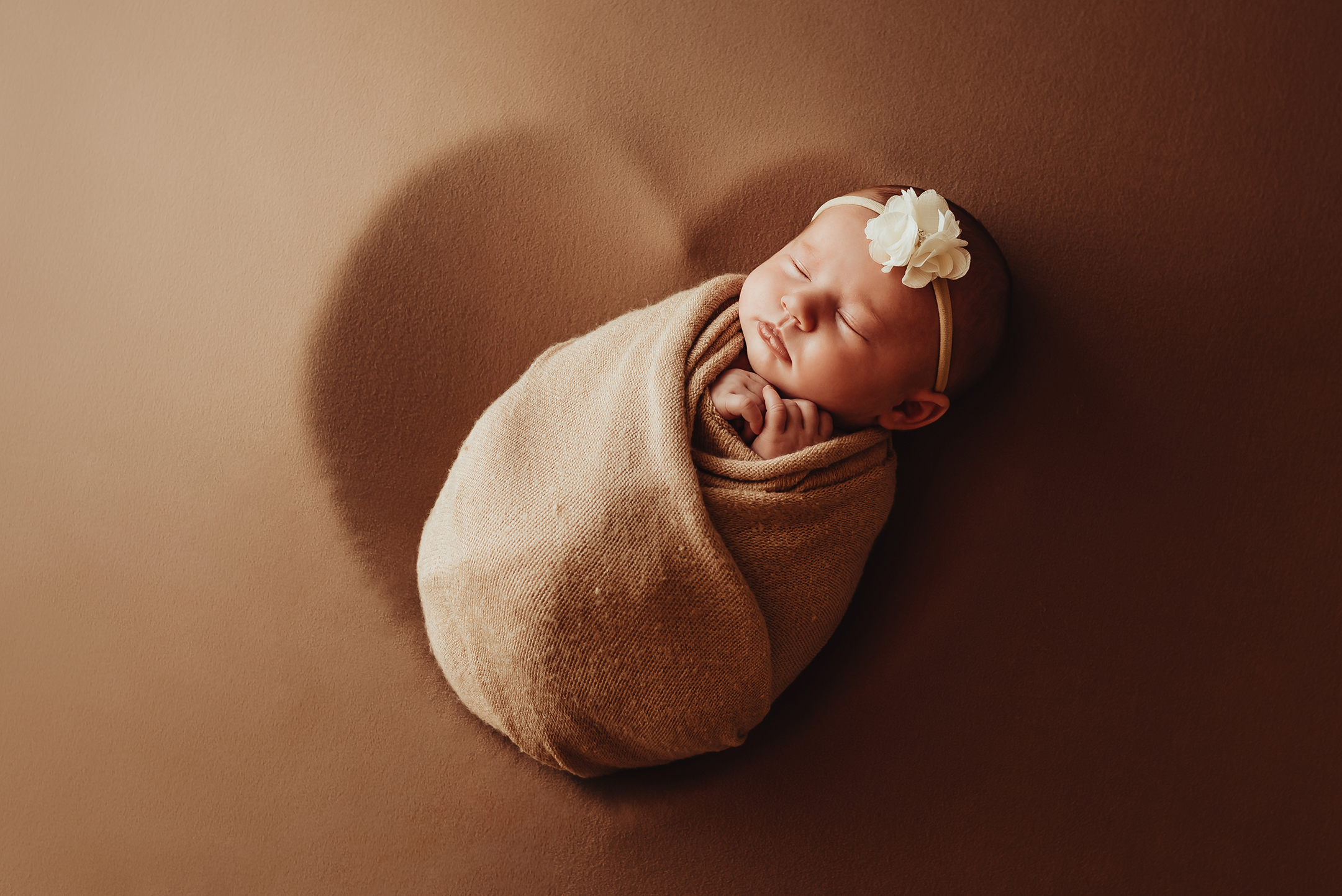 Bébé emmailloté dans un coeur